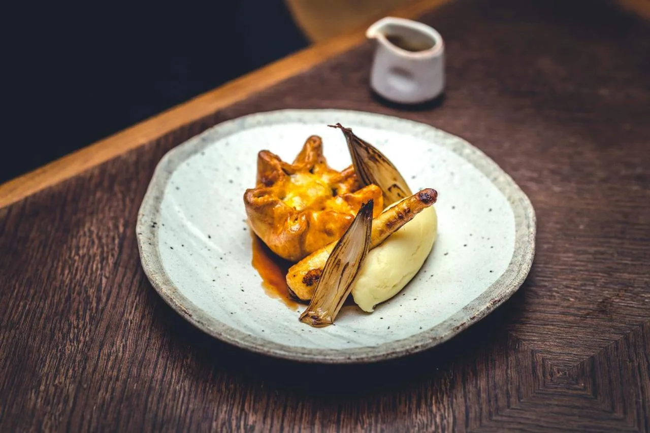 A beautifully plated dish on a wooden table at The Rise Restaurant, York city centre