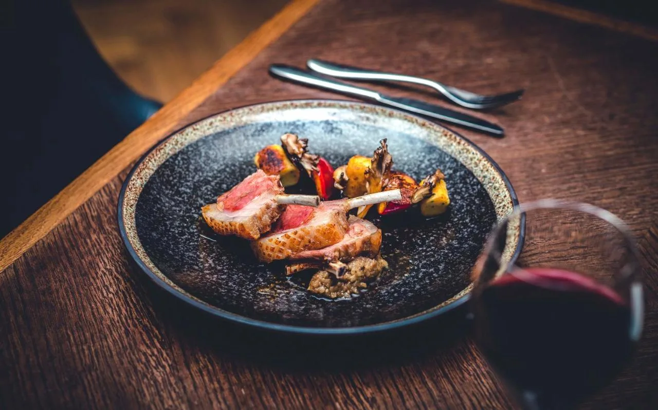 A plated dish with a glass of wine at The Grand, York's restaurant