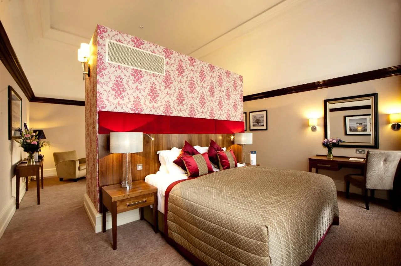 A guest room with a large bed and desk at The Grand, York, near York Station